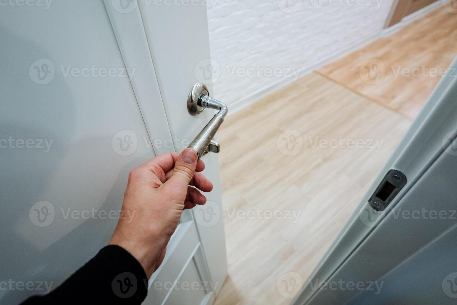 A person is in the process of opening a door while holding a key firmly in their hand, ready to unlock it and gain entry. It is an everyday action that we often take for granted photo