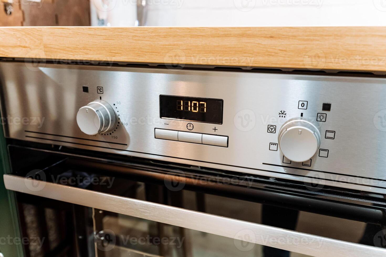 A shiny stainless steel oven is resting atop a beautifully crafted wooden counter, showcasing the perfect blend of modern kitchen technology and classic wood craftsmanship photo