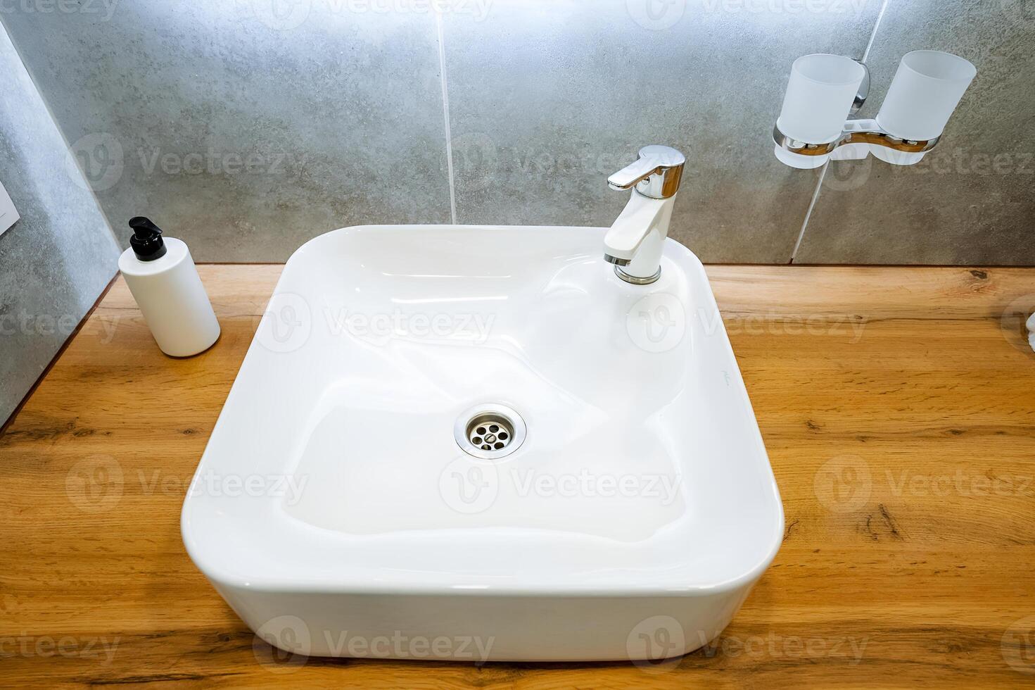The white sink pairs beautifully with the wooden bathroom counter, creating a cohesive look that enhances the rooms appeal aesthetically and blends seamlessly with the surroundings photo