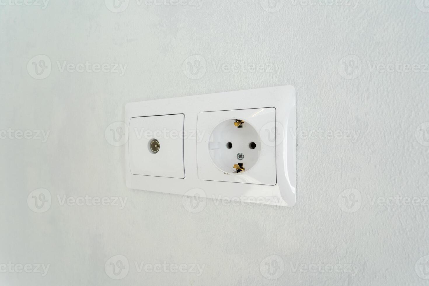 This image features a detailed closeup shot of a white electrical outlet mounted on a pristine white wall, highlighting the simplicity and functionality of the design in this setting photo