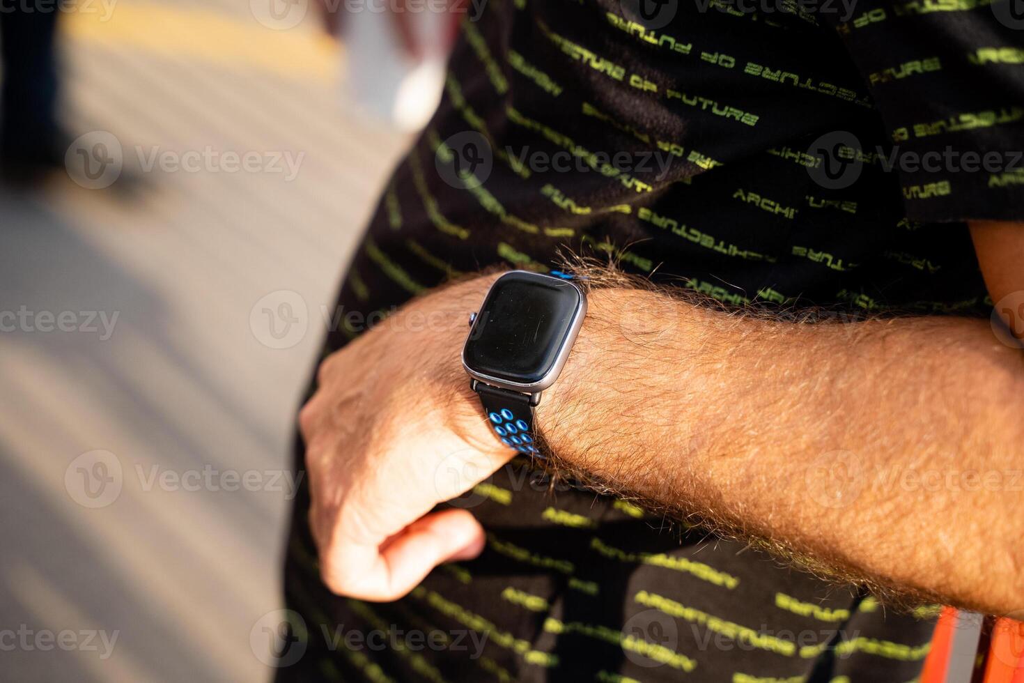 A man is seen with a stylish and modern smart watch adorning his wrist, which showcases the latest technology and trends in wearable accessories, catching the eye of passersby photo