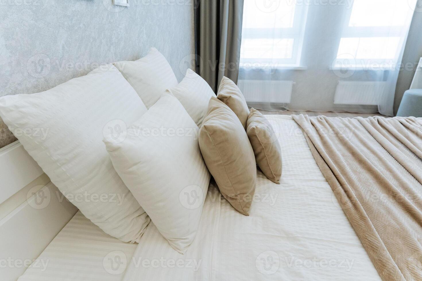 A cozy and beautifully decorated bedroom showcases a neatly made bed dressed in crisp white sheets and fluffy pillows, fostering a warm and inviting ambiance for restful and peaceful nights photo