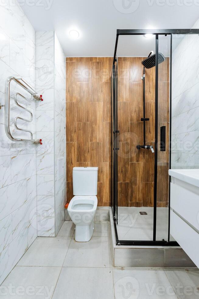 The bathroom consists of essential elements including a toilet, sink, and shower, all of which combine to create a functional space dedicated to personal hygiene and daily routines photo