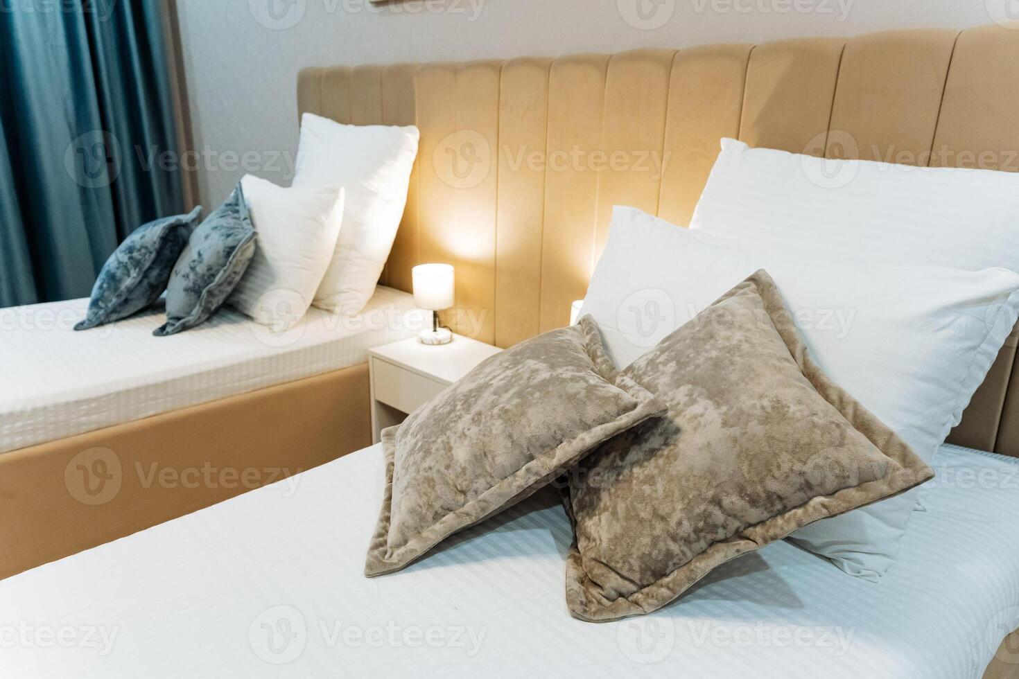 Inside a cozy hotel room, there are two beds neatly made up with soft pillows resting comfortably on them, offering a welcoming space for guests to relax and unwind after their travels photo