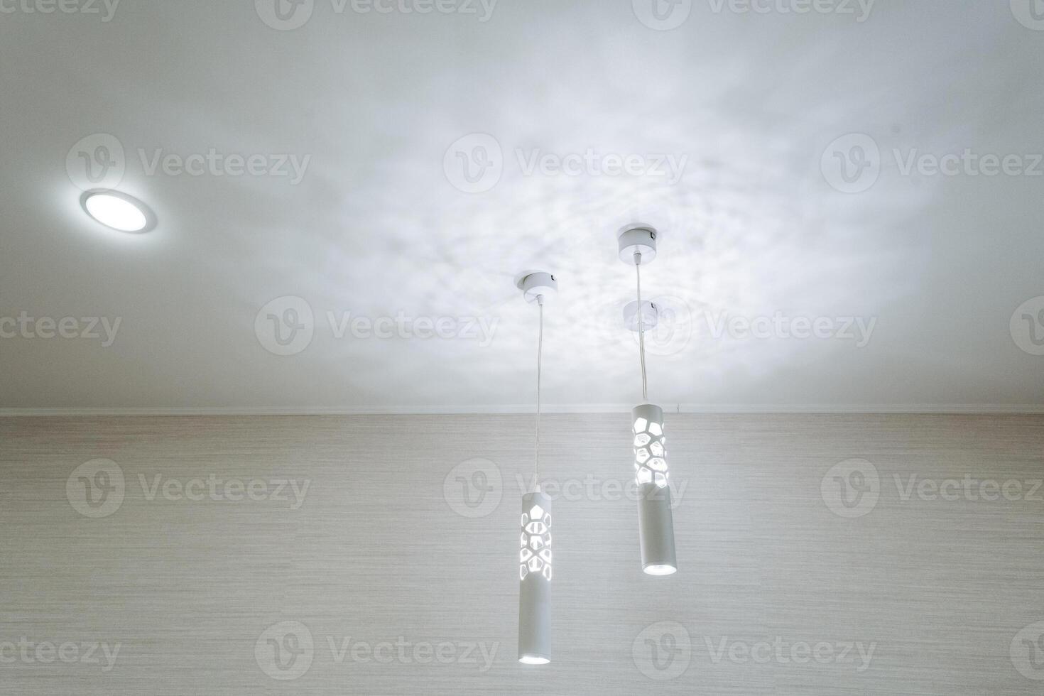The modern ceiling features elegant pendant lights and downlights for a sophisticated and stylish lighting design photo