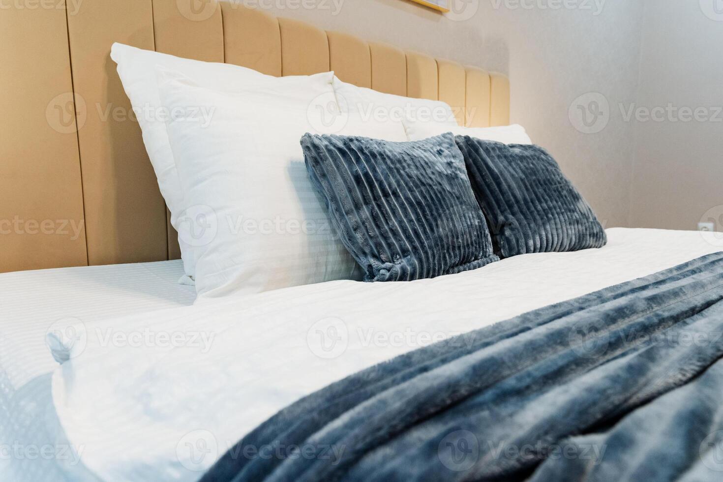 A cozy bedroom features a beautifully arranged bed with white sheets and vibrant blue pillows, fostering relaxation and providing ultimate comfort for a peaceful retreat photo