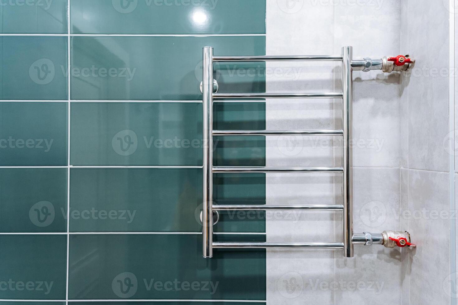 A towel rack is currently and prominently hanging on a tiled wall within a bathroom space, providing a practical and convenient place for drying and hanging towels after use photo