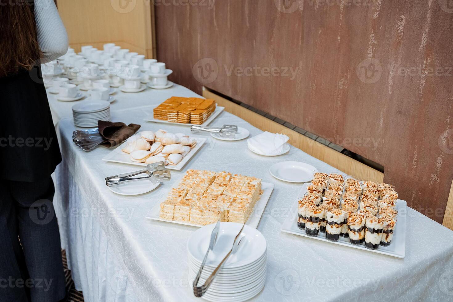 A beautifully set table that features an array of plates filled with delicious food items, accompanied by a pair of tongs placed neatly on the surface of the table for serving photo