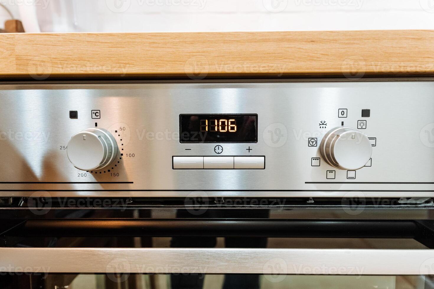 A sleek stainless steel oven is currently positioned on top of a polished wooden counter surface, indicating its role as an essential kitchen appliance in a home setting photo