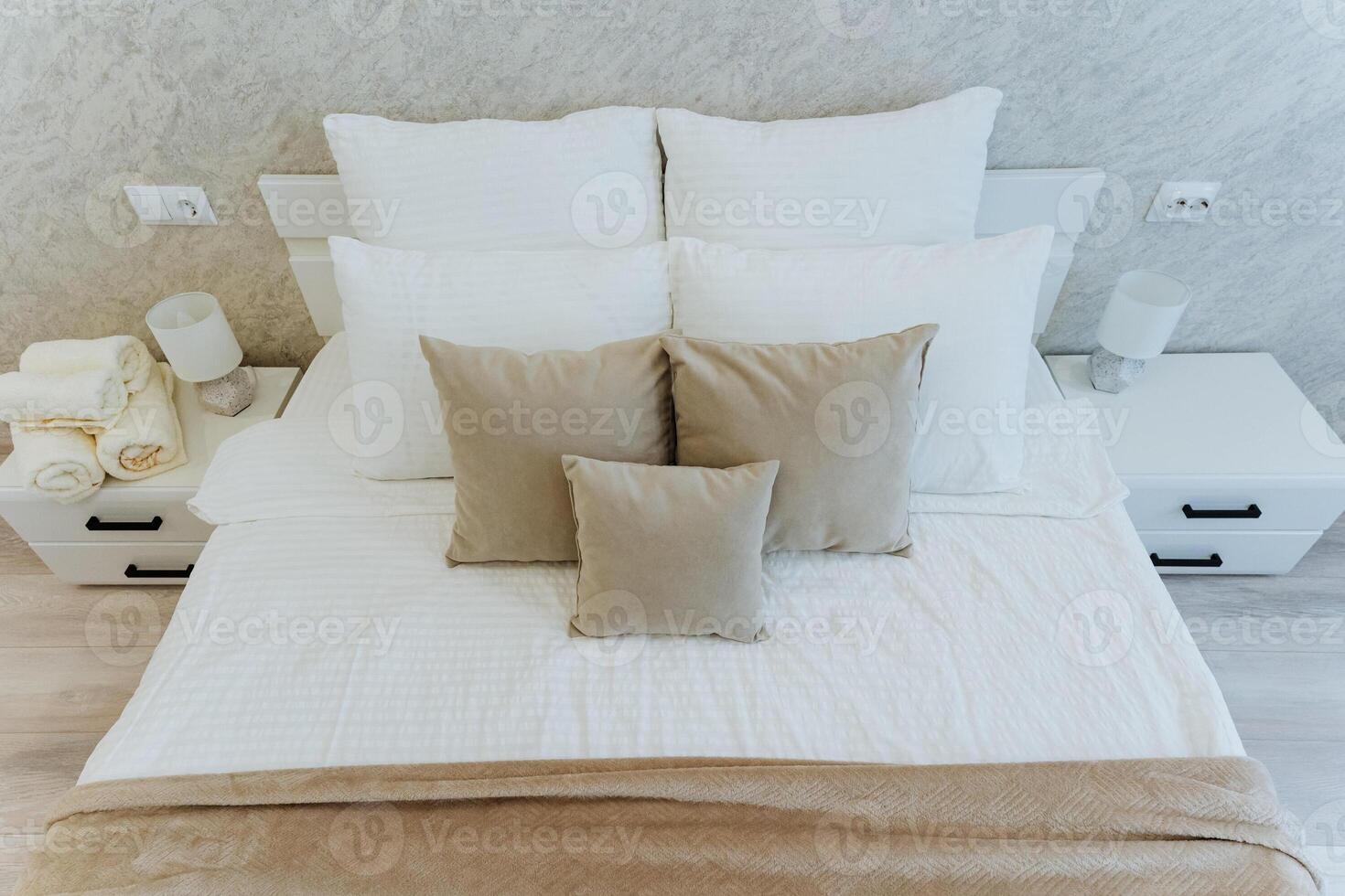 The cozy bedroom has a neatly made bed with soft white sheets and fluffy pillows, creating a serene atmosphere ideal for restful sleep and comfort, making it a delightful retreat photo