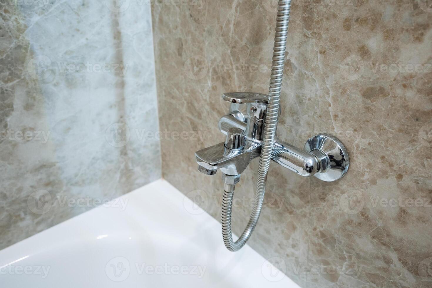A welldesigned bathroom features a spacious bathtub with an overhead shower head, providing users the flexibility to enjoy both bathing and showering at their convenience photo