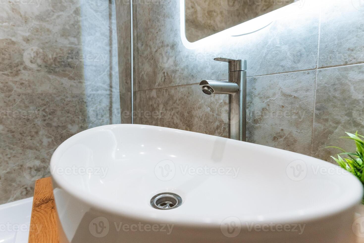 The modern bathroom sink features an elegant faucet and a chic mirror, enhancing everyday use and the overall design, adding style and practicality to this essential space photo