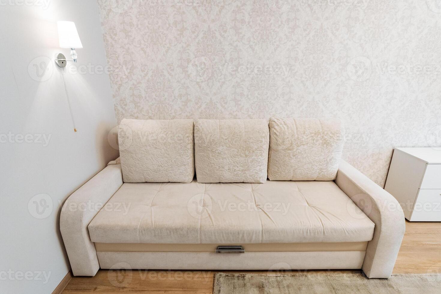 A beige sofa enhances the minimalist living room look, creating a chic, clean, and comfortable space photo