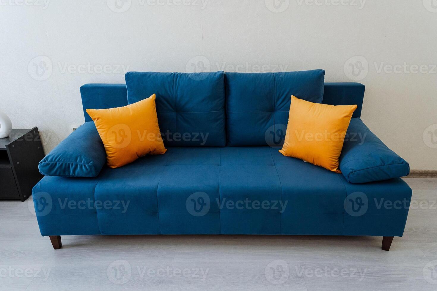In a cozy living room, there is a striking blue couch adorned with vibrant yellow pillows, creating a cheerful and inviting atmosphere that is perfect for relaxation and comfort photo