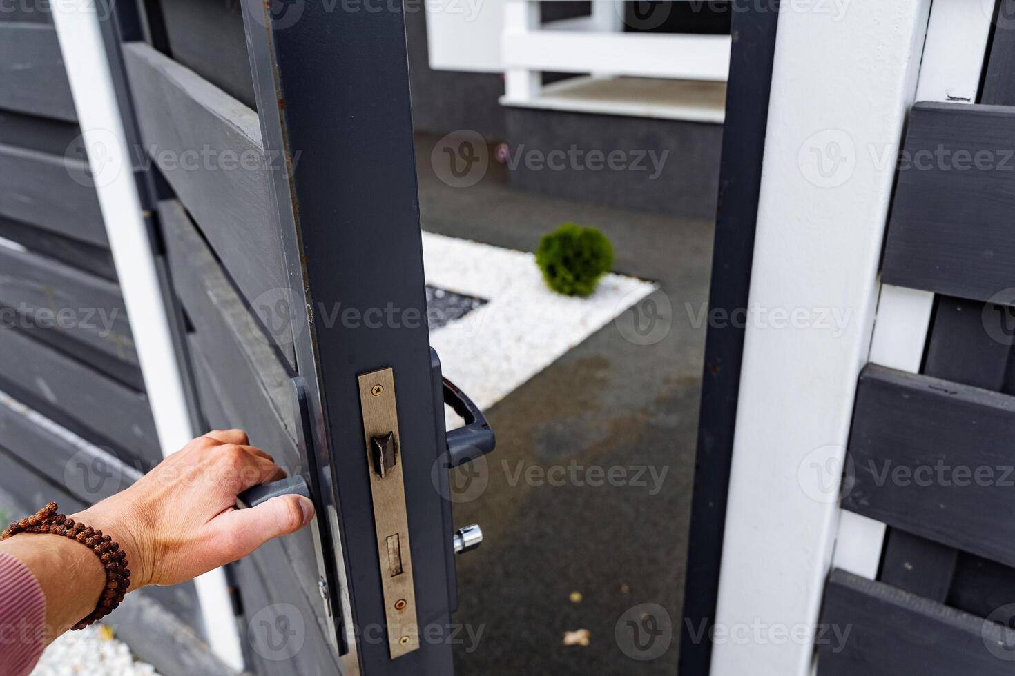 Someone is in the process of opening a beautifully crafted door to a thoughtfully designed house that guarantees comfort and enjoyment for all individuals residing indoors every single day photo