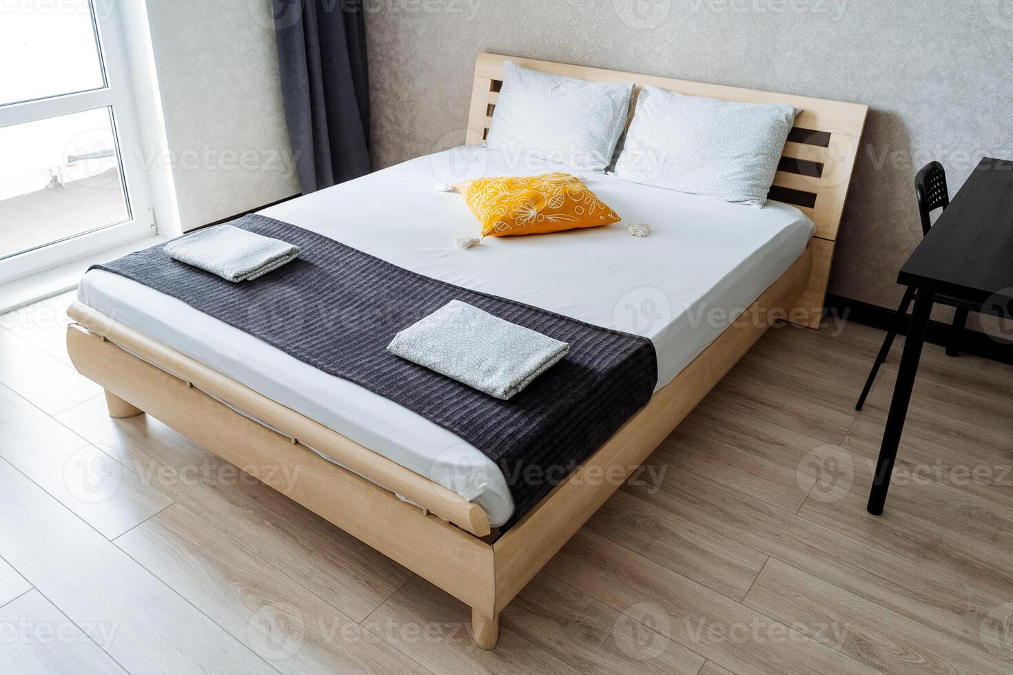 In a cozy bedroom, an inviting bed featuring a sturdy wooden frame adorned with crisp white sheets eagerly calls for relaxation after a long, tiring day filled with numerous activities photo