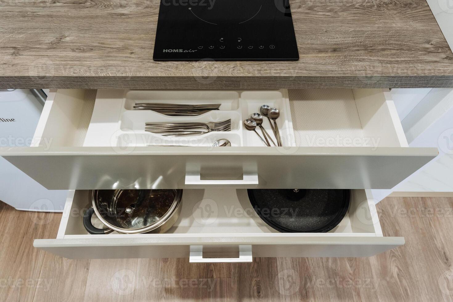 A kitchen drawer that is filled with a variety of kitchen utensils, pots, and pans, showcasing the essential tools for cooking and food preparation in the culinary space photo