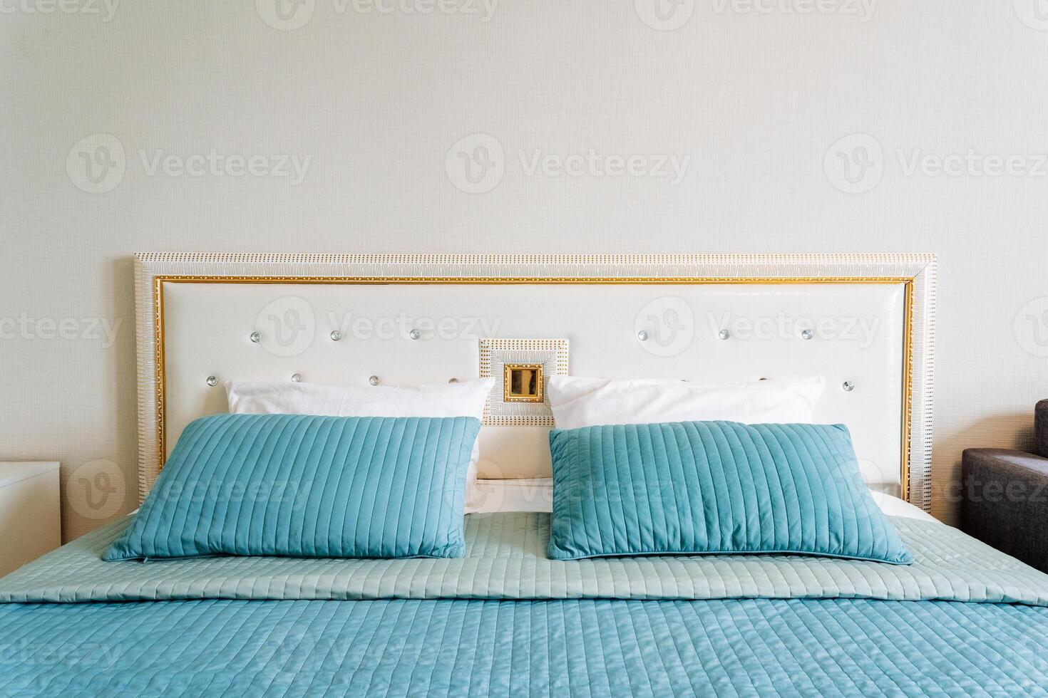 Aqua bedding and pillows on wood bed frame in rectangular bedroom fixture photo