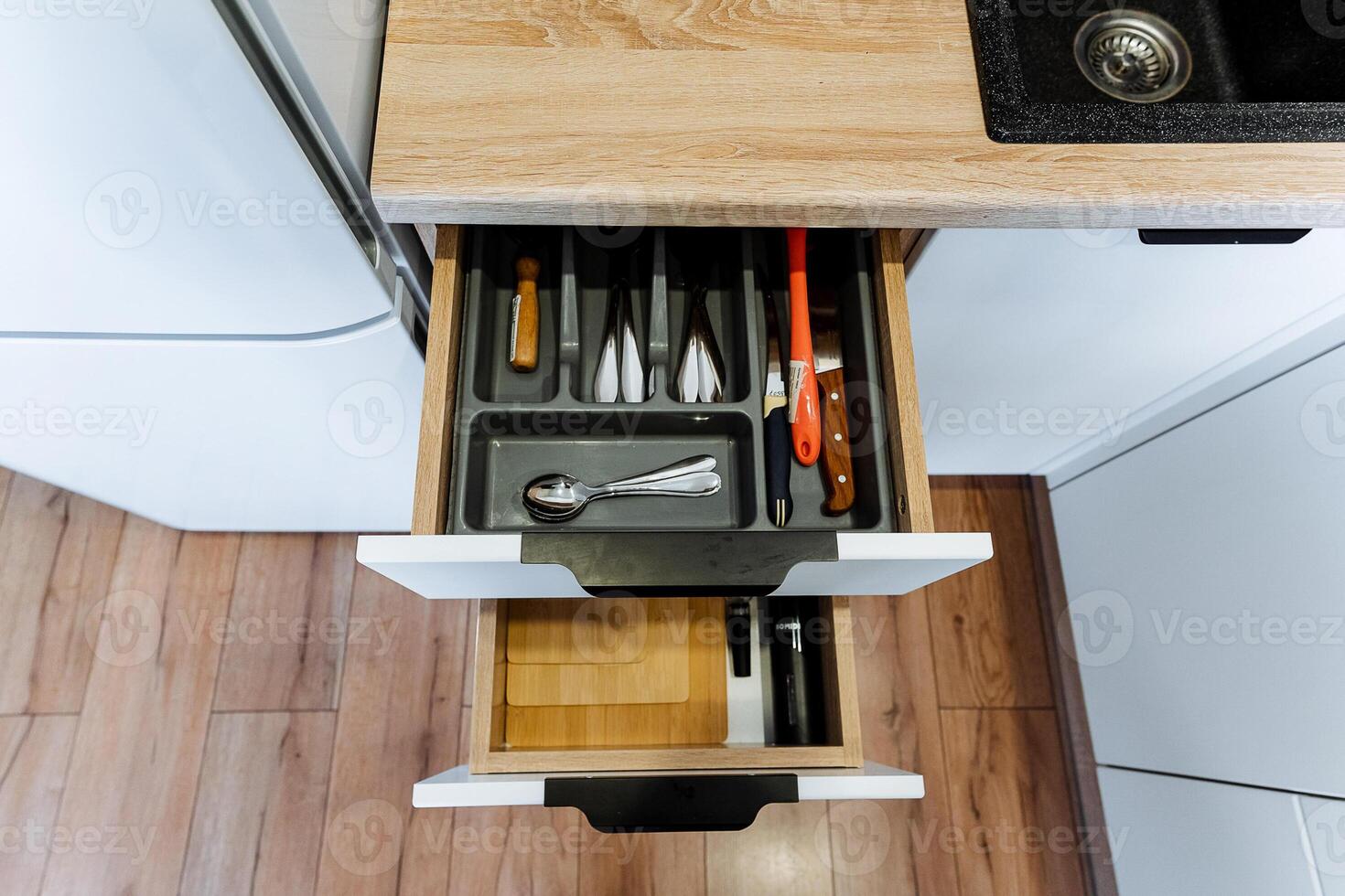 This kitchen features a standout drawer that is filled with a fascinating assortment of utensils and knives, showcasing its careful organization and specific purpose for culinary tasks photo
