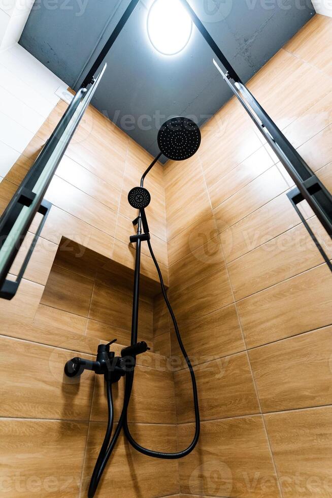 The spacious and beautifully designed bathroom showcases a stylish ceilingmounted shower head, providing an exceptionally refreshing experience for anyone who is enjoying a calming shower photo