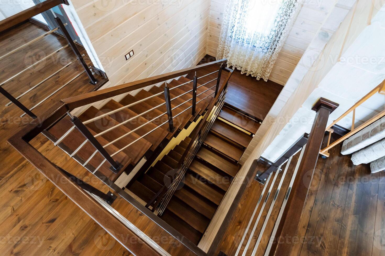 A beautifully crafted wooden staircase with a sleek metal railing gracefully integrated within the interior of a modern house, adding both functionality and aesthetic appeal photo