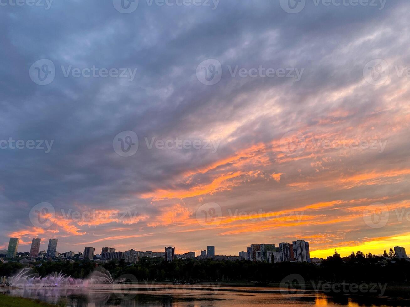 Imagine witnessing a breathtaking sunset over a serene lake, with a bustling city skyline visible in the distance, creating a picturesque view that perfectly captures natures beauty photo