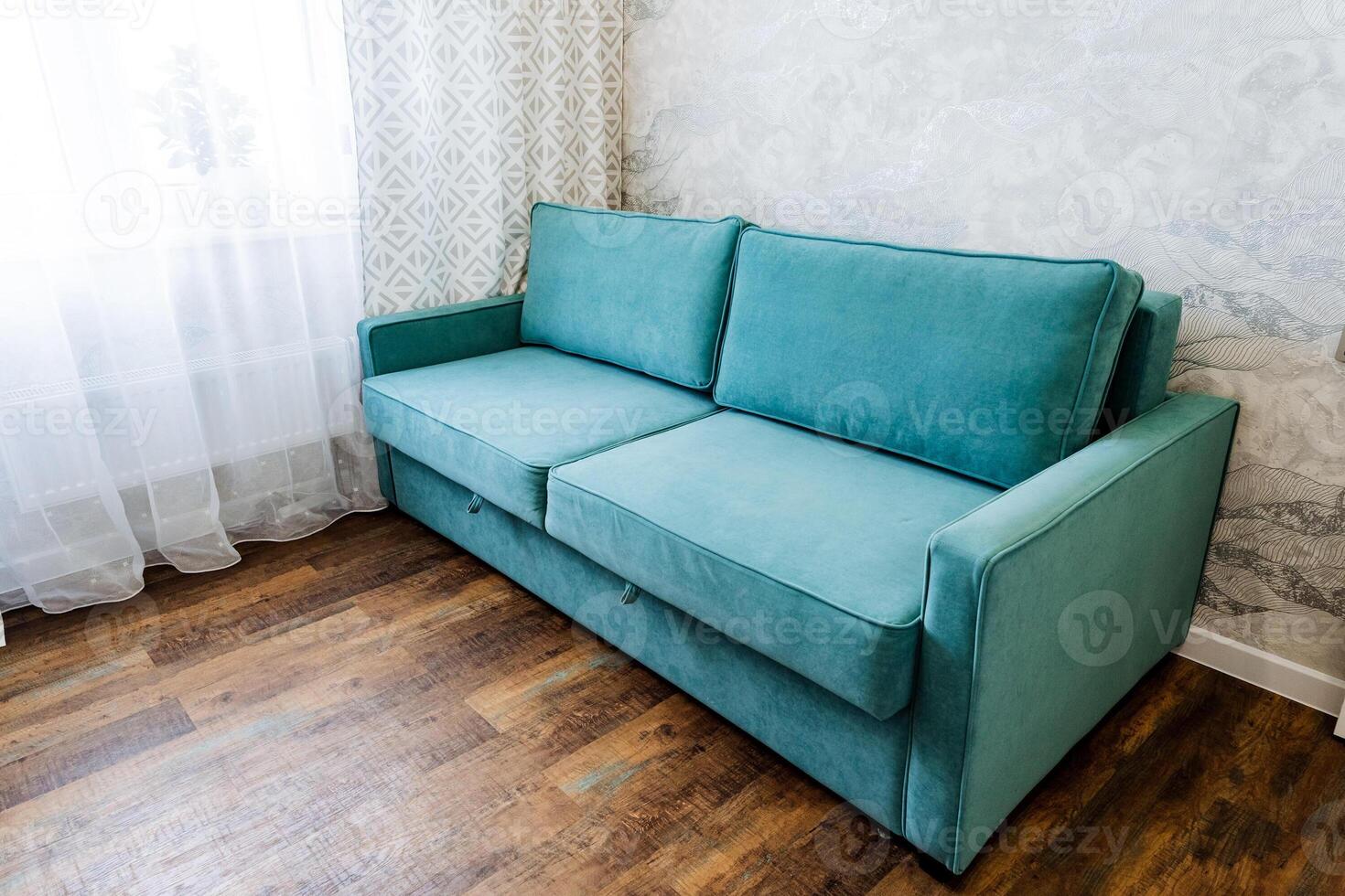 Electric blue couch as a fixture in a living room, located next to a window photo