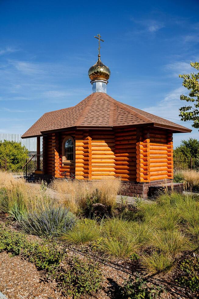 A quaint and charming small wooden church prominently features a lovely cross atop its structure, which significantly enhances its overall appeal amidst the gorgeous surrounding scenery photo