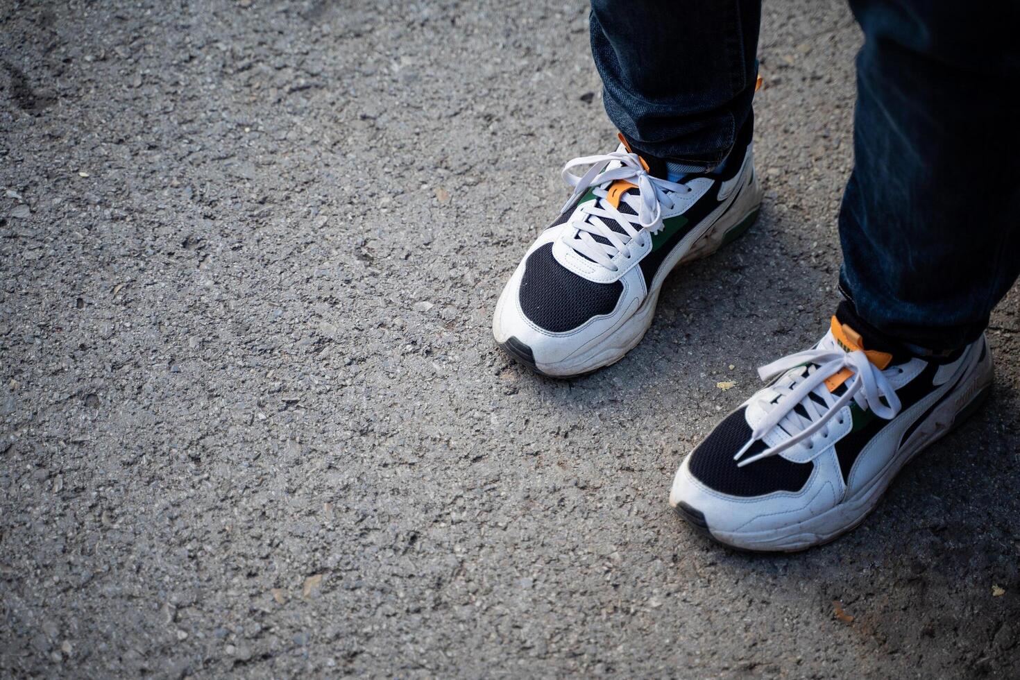 A person is currently wearing a stylish and fashionable pair of black and white sneakers that are perfect for casual outings or athletic activities, providing comfort and support photo