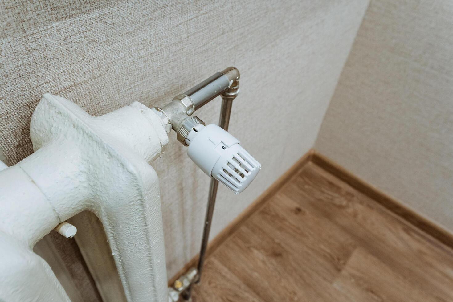 This image features a detailed closeup of a radiator, which is equipped with a thermostat attached prominently to it, showcasing the intricate design and functionality of heating systems photo