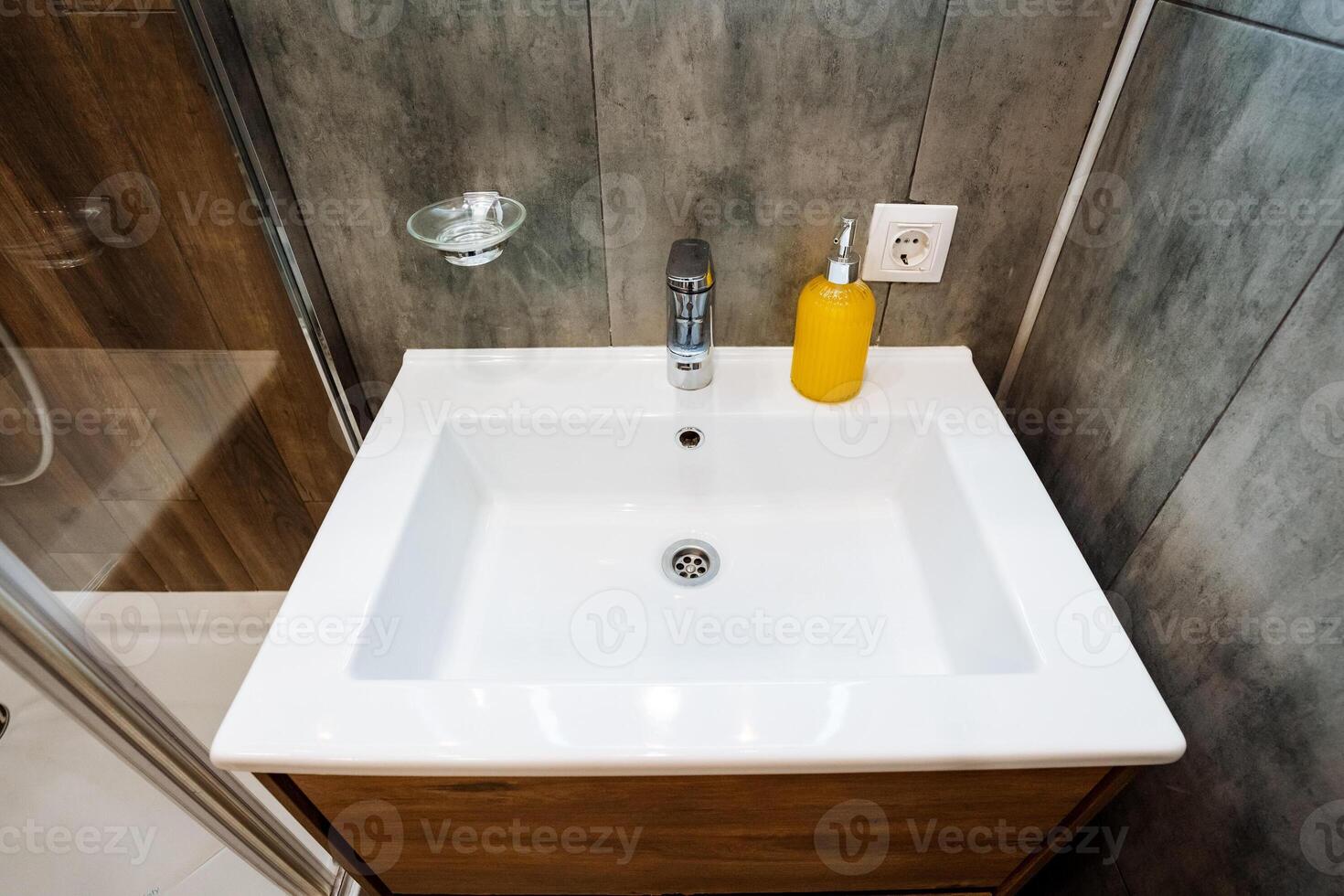 A bathroom sink that features a convenient soap dispenser placed on top of its surface, making it easy to access soap for hand washing and ensuring cleanliness in the washroom photo