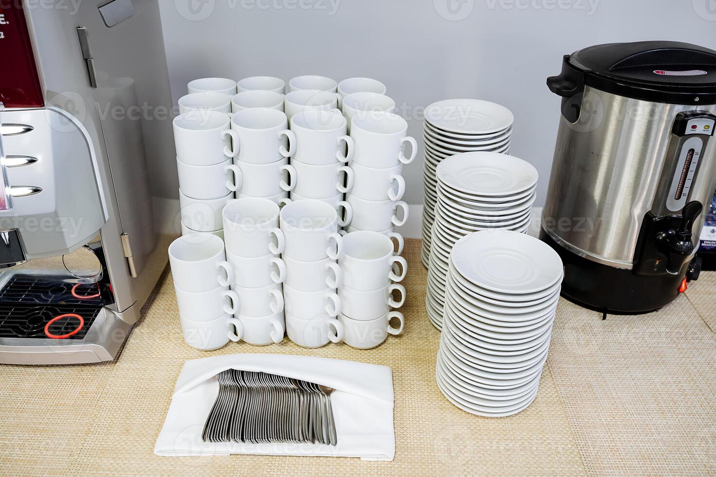 A stack of coffee cups and saucers on a table contributes to a cozy atmosphere, reflecting warmth and hospitality, creating a welcoming environment for guests with a comforting touch photo