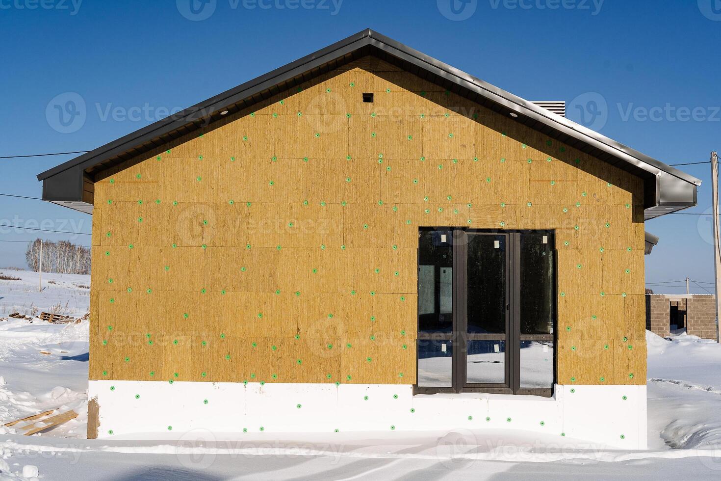 Insulation of the building, installation of a warm layer on the wall of the house, mineral wool, the foundation is lined with foam, thermal insulation of the house from the street. photo