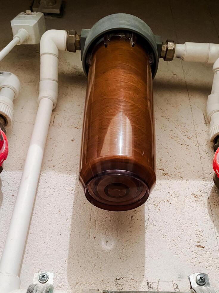 Here is a closeup view of a water filter that features striking red handles, which adds a vibrant touch to its design and functionality, making it an essential part of plumbing photo