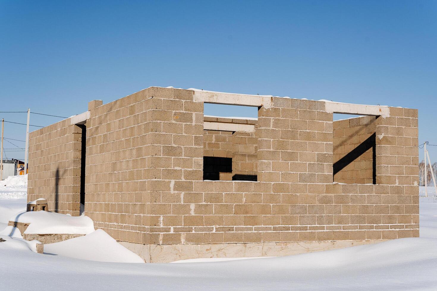 A brick building with a snowy facade is rising against the sky on a snowy slope photo