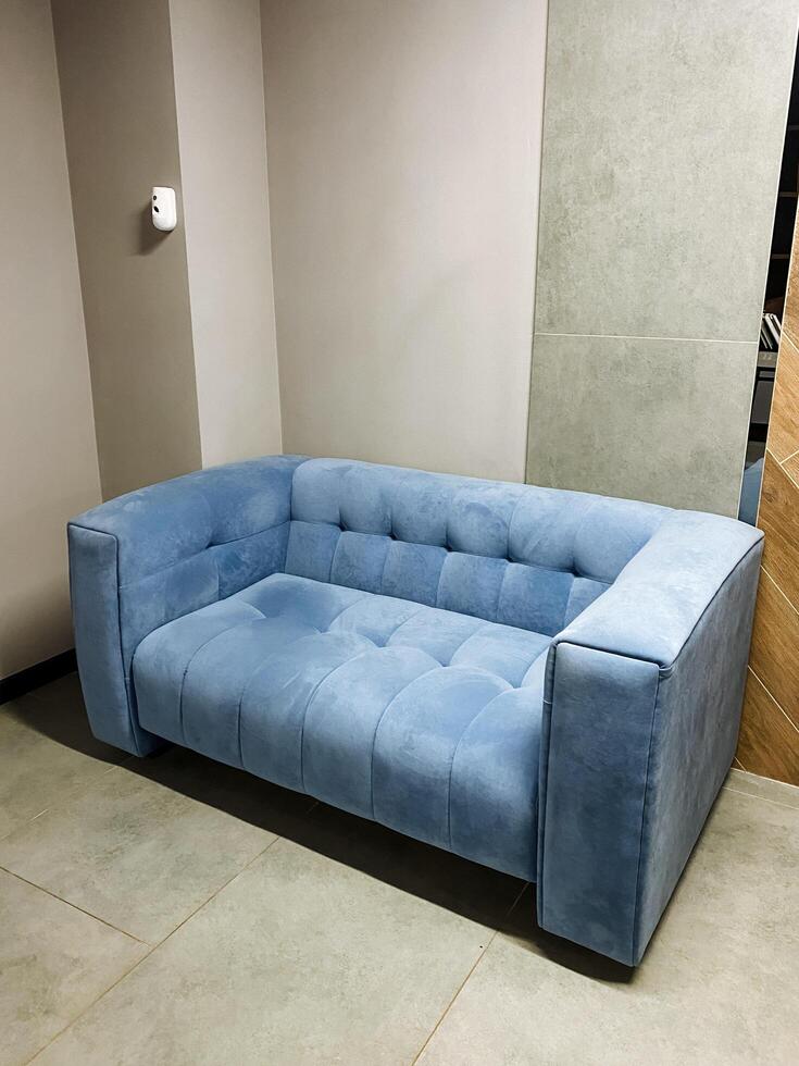 A cozy and inviting living space showcases a stunning blue couch beautifully positioned against a wall, enhancing the vibrant color and ultimate comfort of the rooms overall ambiance photo
