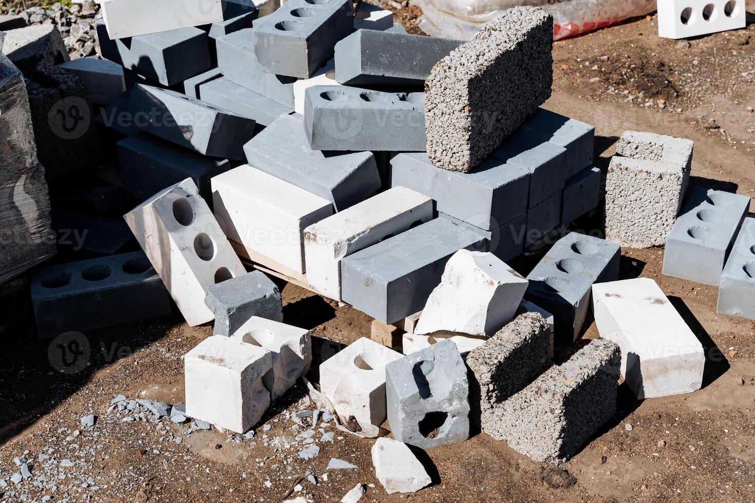 Heap of construction blocks and concrete bricks at building site in sunlight. Pile of durable materials for industrial work, urban planning, and infrastructure development photo