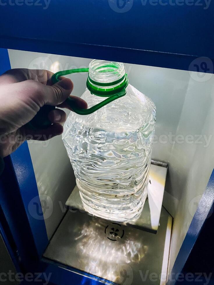 A person is firmly holding a bottle of water that features a distinct green handle, showcasing the container designed for carrying and consuming water conveniently and efficiently photo