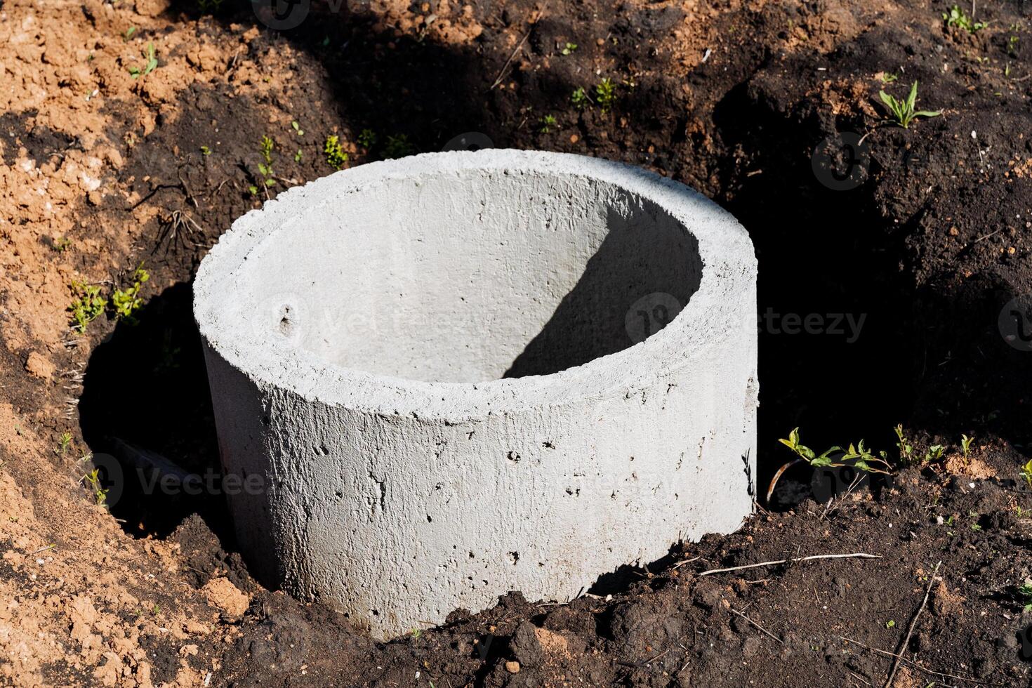A concrete drainage pipe is ready for installation in freshly dug earth on a construction site. This infrastructure project is essential for water management and sanitation photo