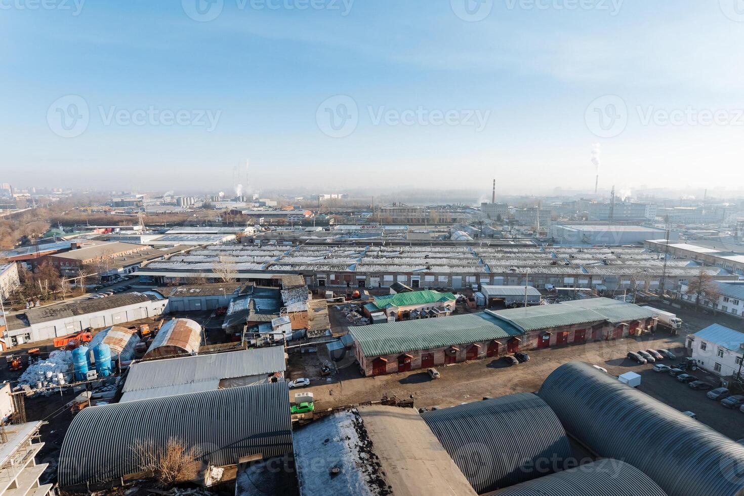 An expansive aerial view showcasing a bustling city dotted with numerous buildings set against a clear blue sky, illustrating the vibrant urban landscape and architectural diversity photo