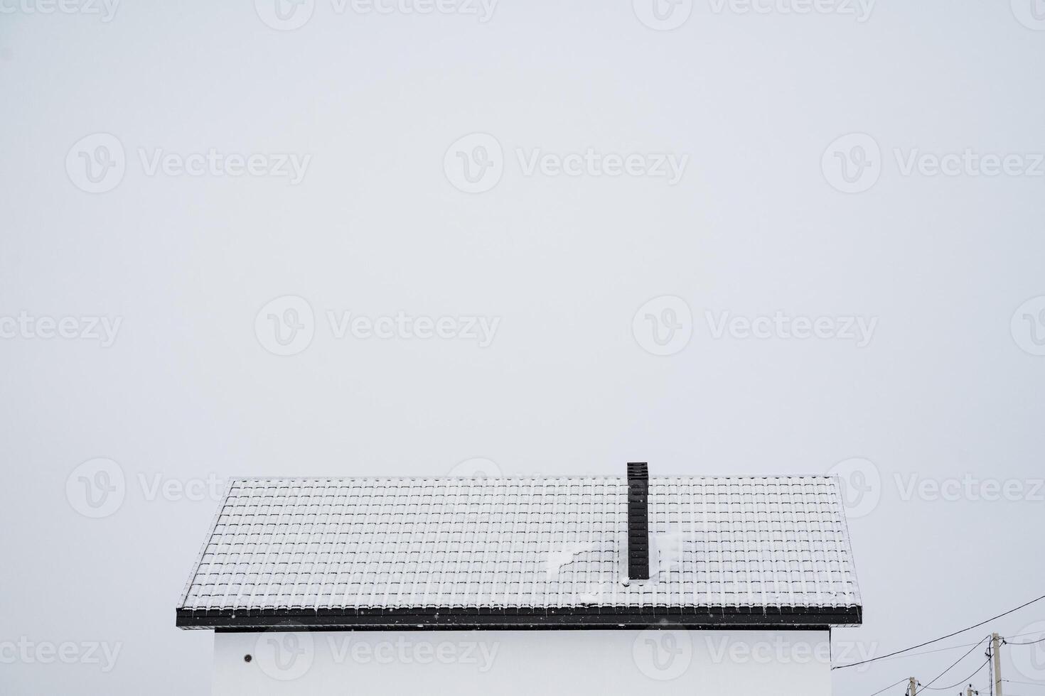 A white house featuring a distinctive black chimney that sits prominently on its roof, enhancing its aesthetic appeal and contrasting nicely with the white exterior of the building photo