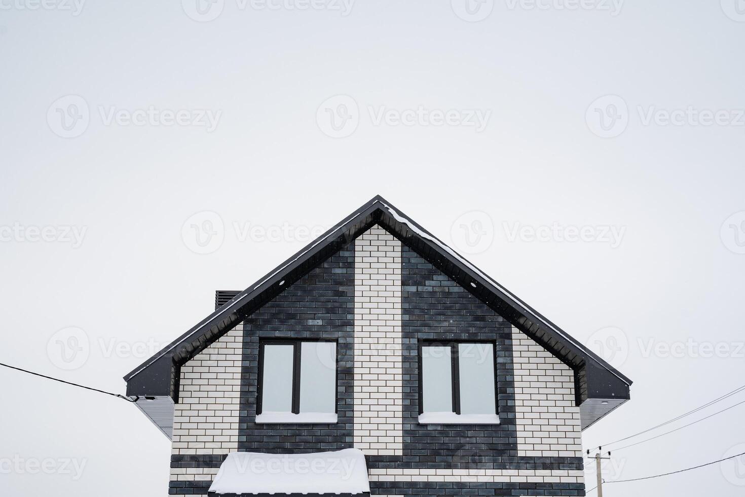 This stunning modern winter home is exquisitely designed and nestled in a serene, picturesque snowy landscape, showcasing the charm, beauty, and tranquility that the season brings photo