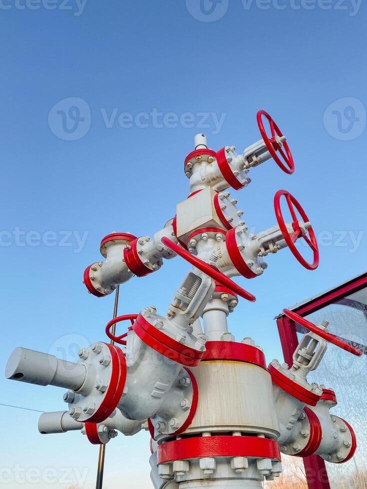 The image shows an Industrial Valve System against a vibrant blue sky, highlighting its intricate components and essential engineering connections for functionality photo