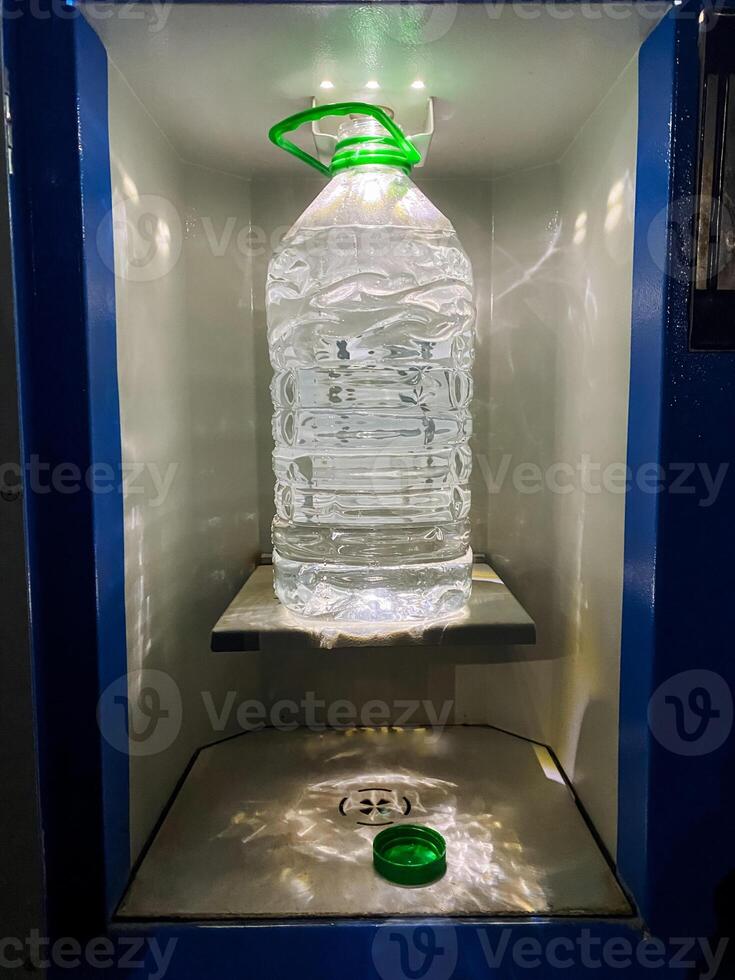 A bottle of refreshing water is currently positioned on a shelf in a vending machine, eagerly waiting to be chosen and savored by a thirsty customer in need of essential hydration photo