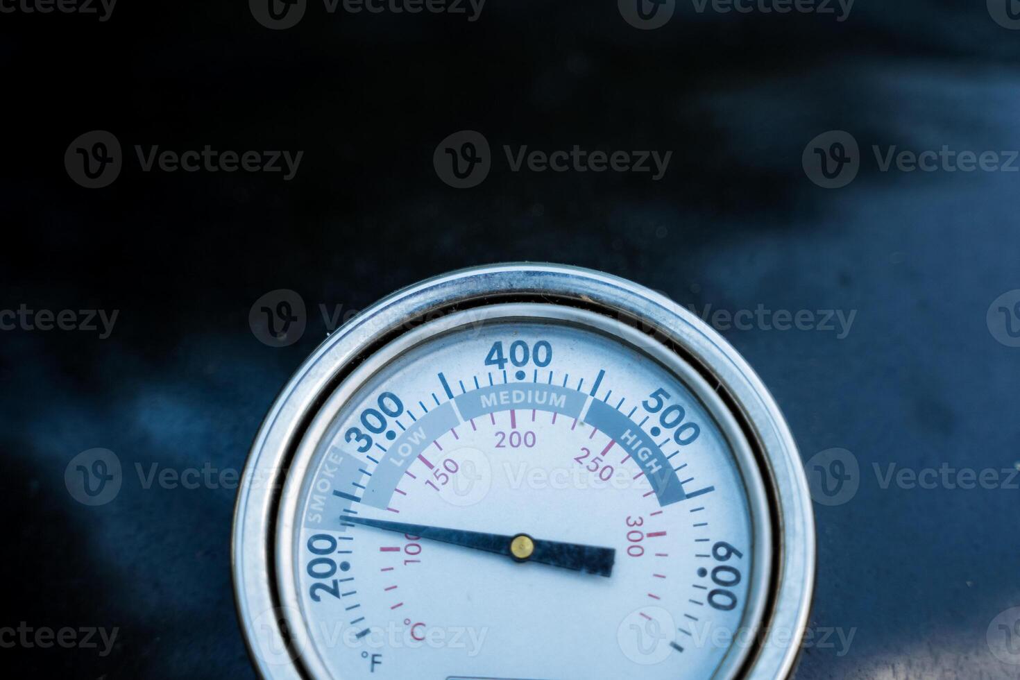 The closeup photograph captures a thermometer showing a high temperature of 400 degrees, highlighting its details clearly and emphasizing the measuring instruments features photo
