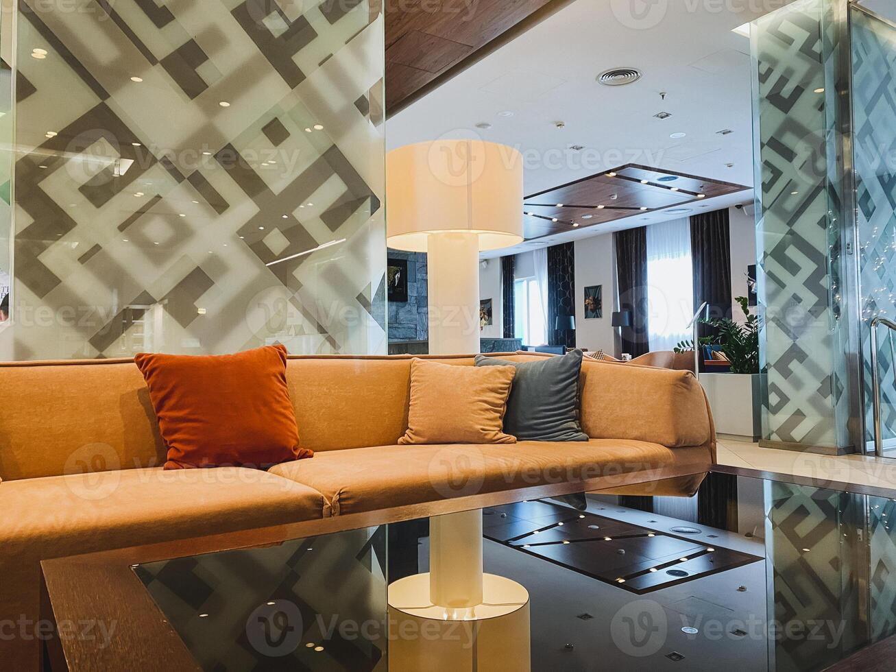 This exquisitely designed living room boasts a cozy couch, a stylish elegant table, and a warm lamp, all of which come together to create a truly comforting and inviting atmosphere photo