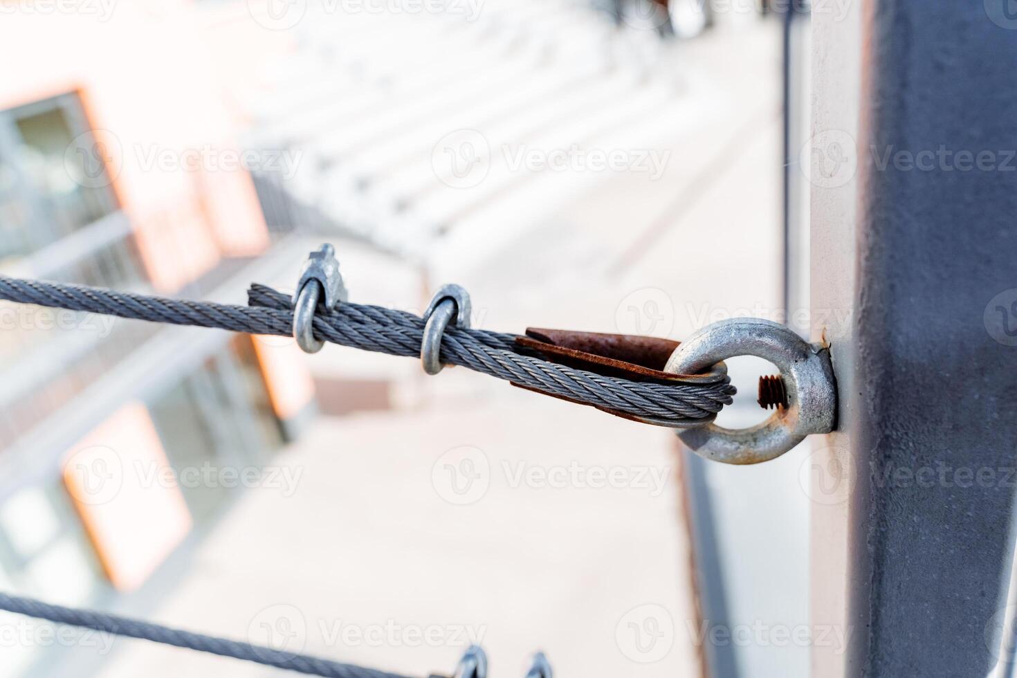 Close up of metal pole with attached rope, part of security fencing photo
