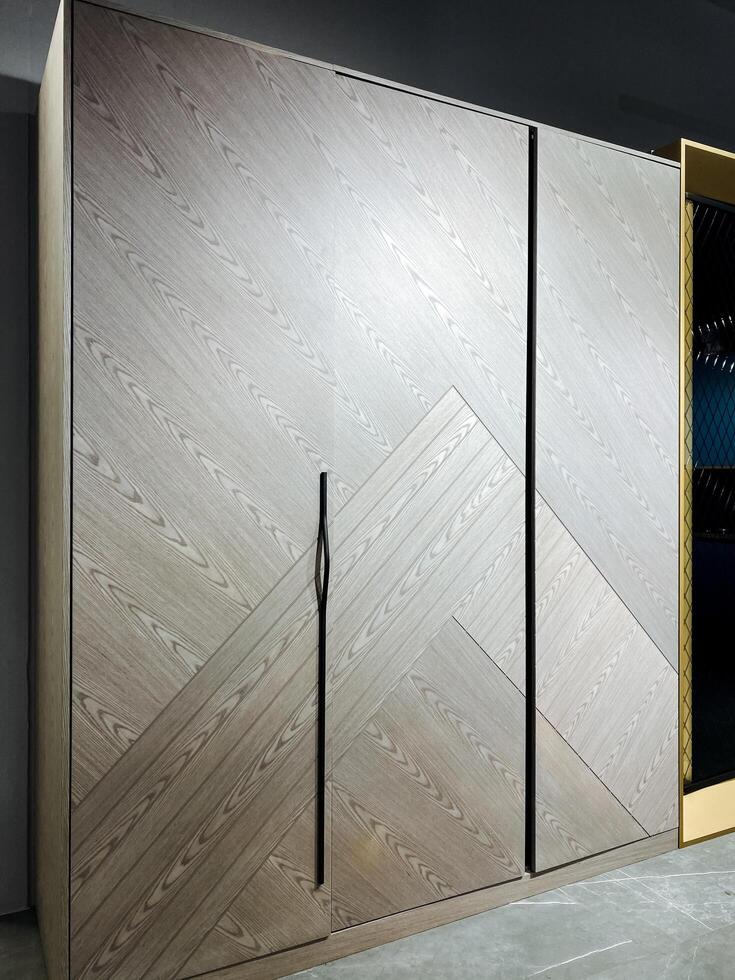 In a spacious and beautifully designed room, there stands a large wooden wardrobe featuring sliding doors that not only adds function but also brings an elegant touch to the overall decor photo