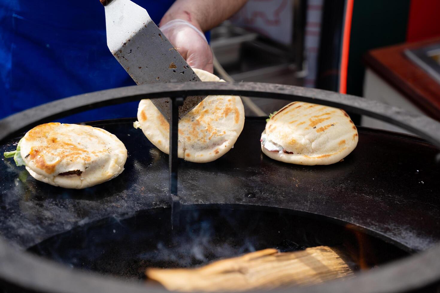 A person is actively and skillfully cooking food on a grill using a spatula as they prepare a delicious meal, showcasing their culinary skills and creativity in the kitchen photo