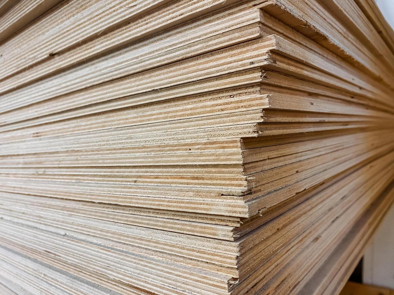 This closeup image shows a neatly stacked pile of plywood sheets, highlighting the intricate textures and patterns of this essential material used in construction and design photo